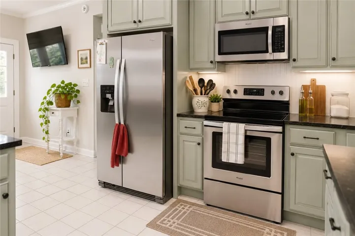 A well-equipped kitchen features sleek stainless steel appliances and light-toned cabinetry.