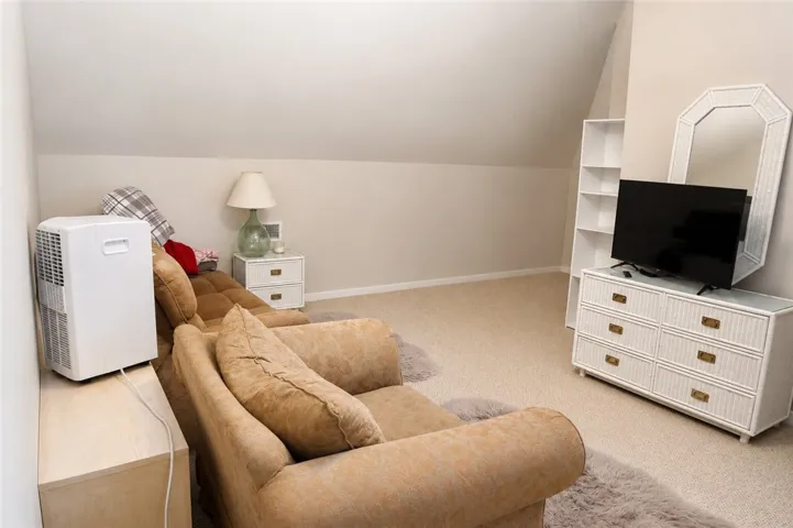 Comfortable bonus room with wall-to-wall carpeting and sloped ceilings provides a cozy retreat.