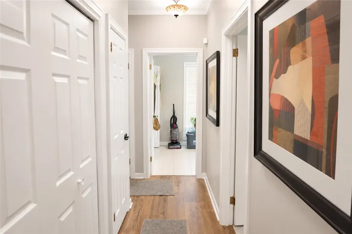 A well-lit hallway with natural wood flooring offers easy access to various rooms.