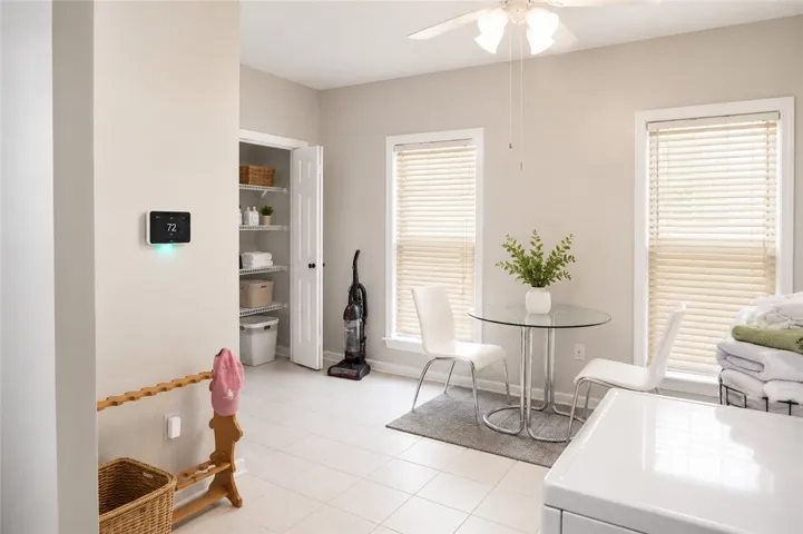 This spacious utility room offers ample storage, bright window light, and durable tile flooring for practical living.