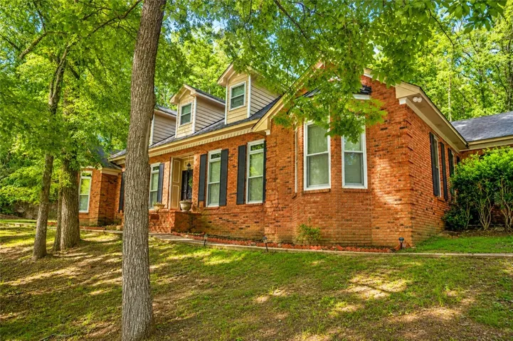A classic brick exterior, framed by mature trees, welcomes you to this charming residence.