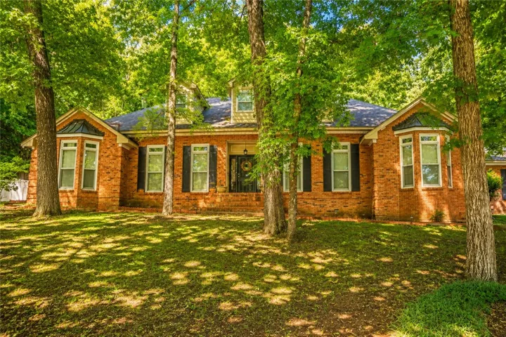 Mature trees frame this traditional brick residence, offering ample curb appeal and natural shade.