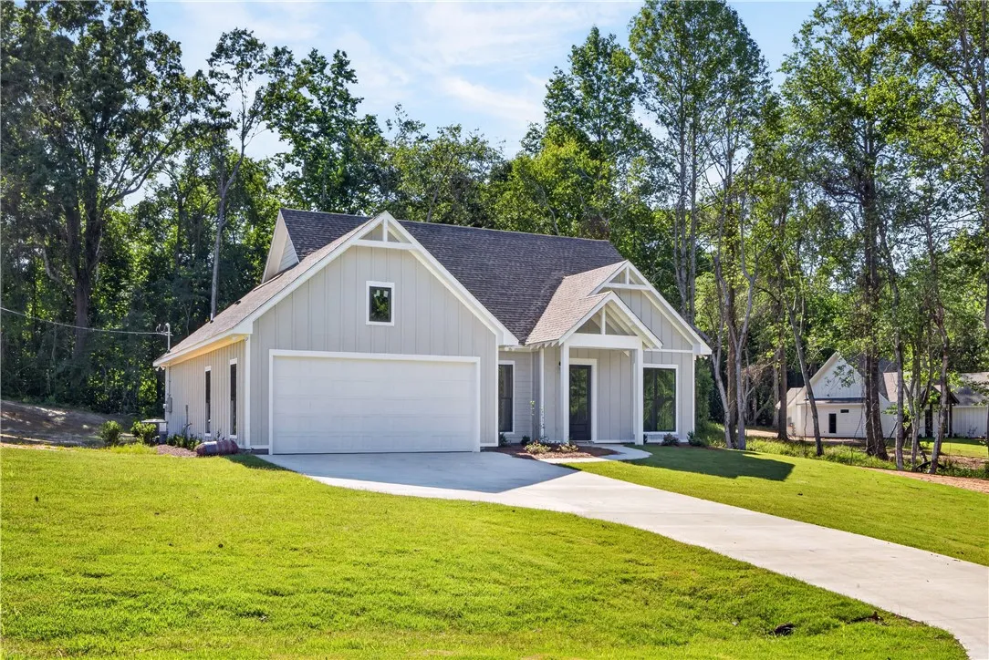 A newly constructed residence framed by mature trees, offering a clean, contemporary facade and a generous driveway.