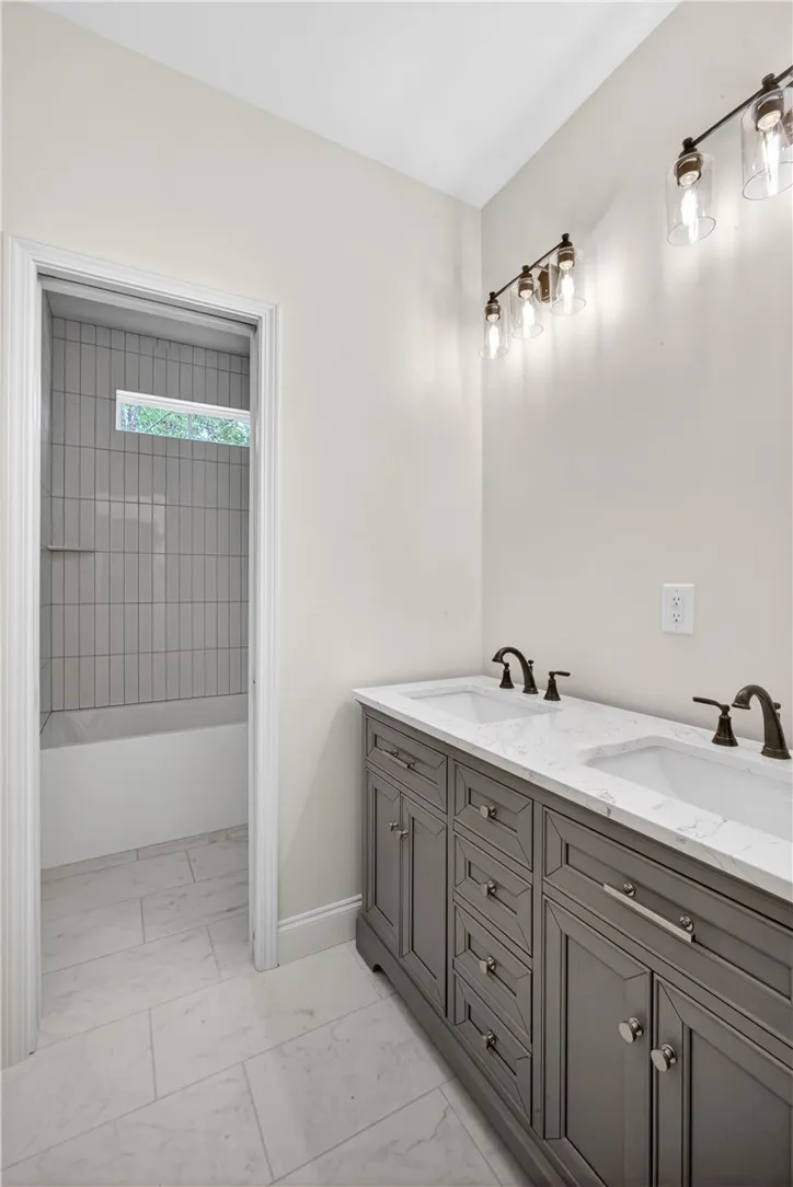 A well-appointed bath features a double vanity and sleek modern fixtures.