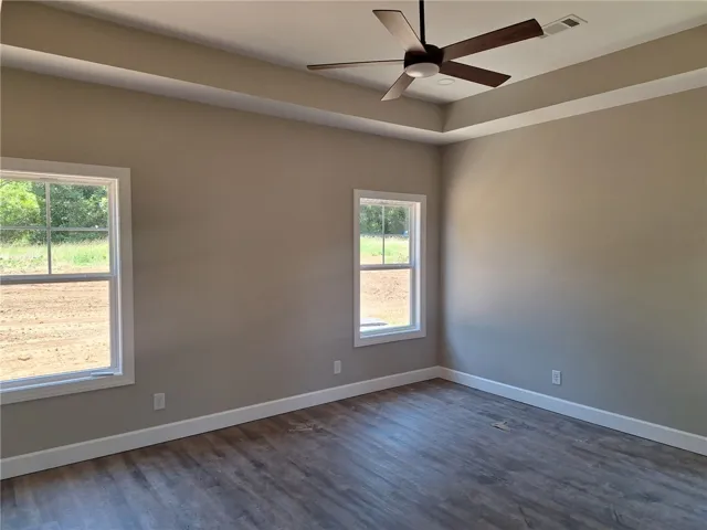A tray ceiling and abundant natural light enhance this spacious, empty room, ready for personalization.