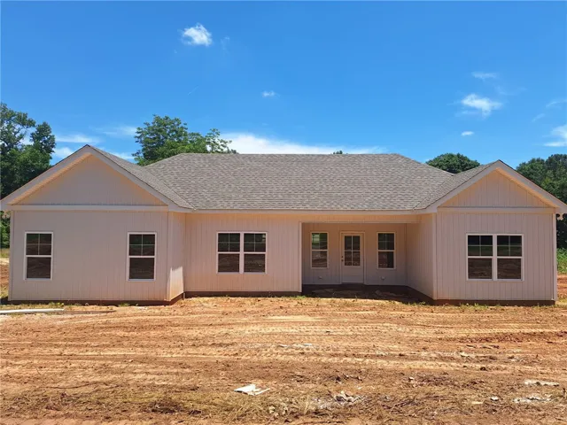 A newly constructed residence awaits customization, set on a spacious lot under a clear sky.