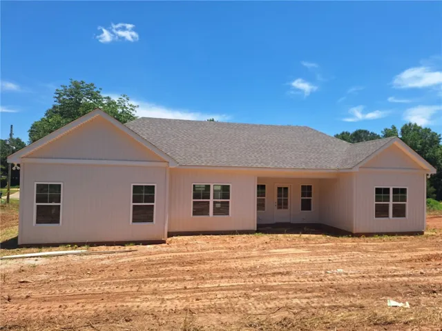 A newly constructed residence awaits customization, featuring classic siding and a traditional gabled roof.