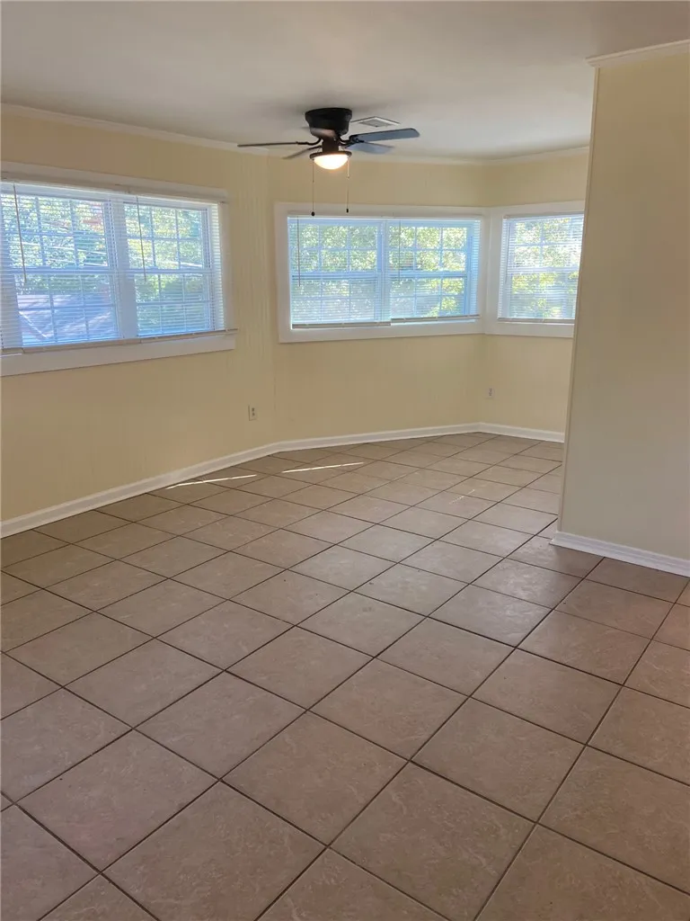 Well-lit room with bay windows and durable tile flooring awaits your personal touch.