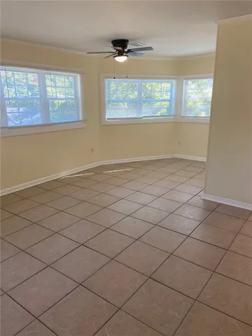 Well-lit room with bay windows and durable tile flooring awaits your personal touch.