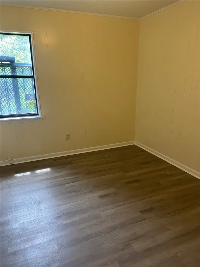 A quiet room featuring light-toned paneling and durable wood-look vinyl flooring.