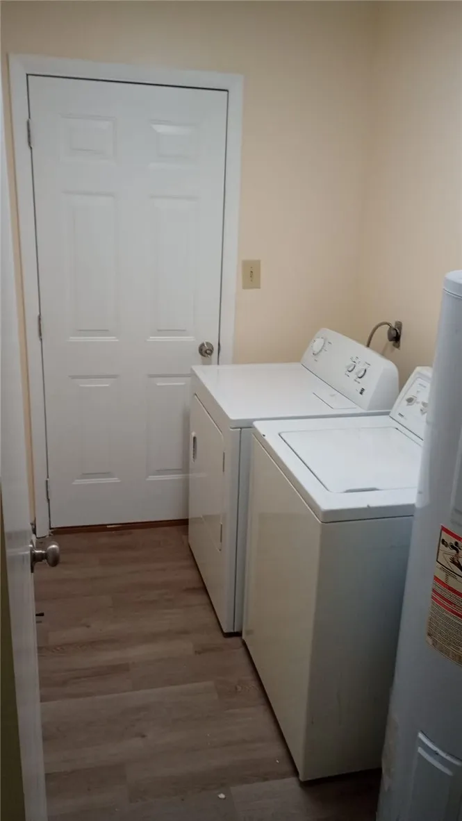 Functional utility room featuring modern appliances and durable wood flooring.