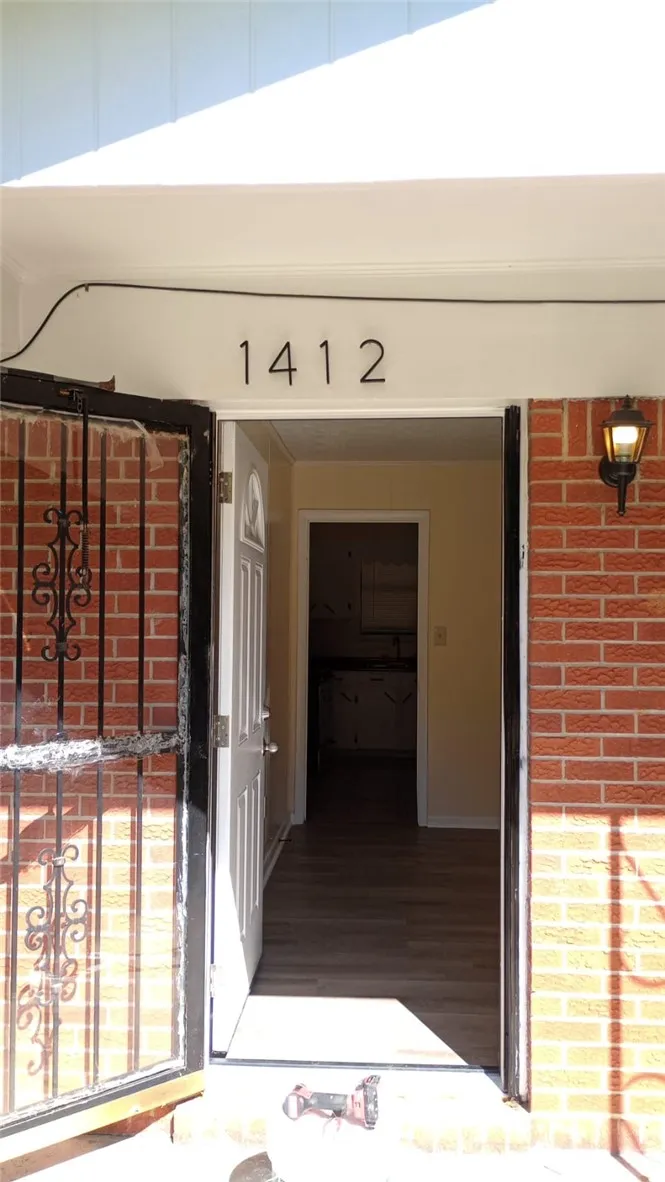 A welcoming entry, with a classic brick exterior, invites you inside to discover newly installed wood flooring.