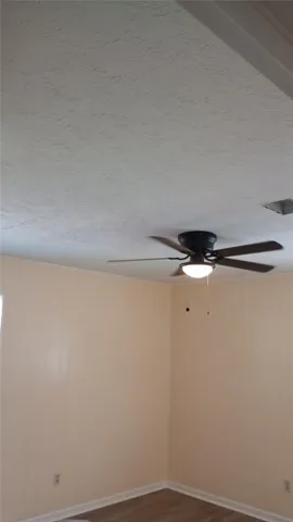 Comfortable room with paneling and ceiling fan, perfect for a cozy living space.