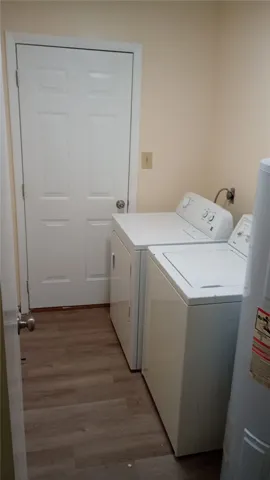 Functional utility room featuring modern appliances and durable wood flooring.