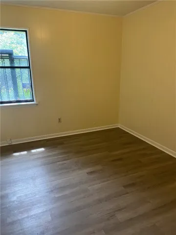 A quiet room featuring light-toned paneling and durable wood-look vinyl flooring.