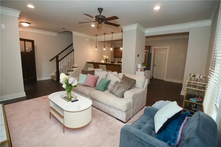 Hardwood floors flow through this open-concept living area with a ceiling fan and recessed lighting.