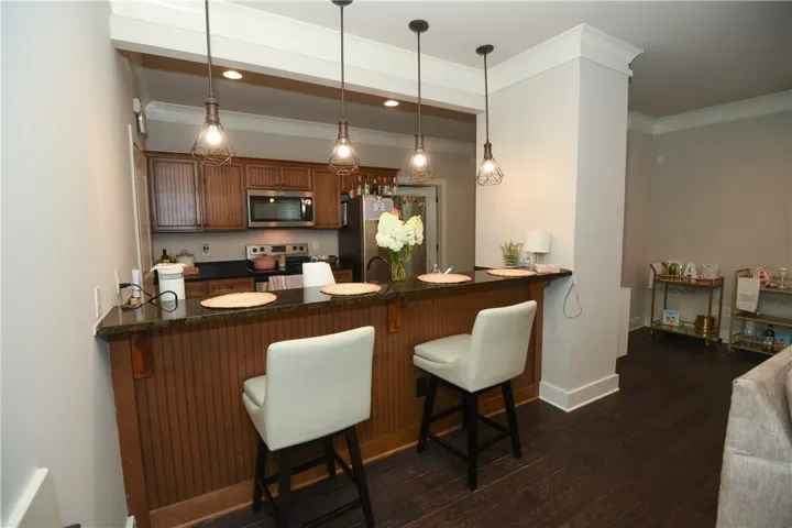 Granite counters and stainless steel appliances outfit this appealing kitchen, complete with a kitchen bar.