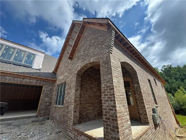 A newly constructed residence showcasing brick construction and an arched entryway.