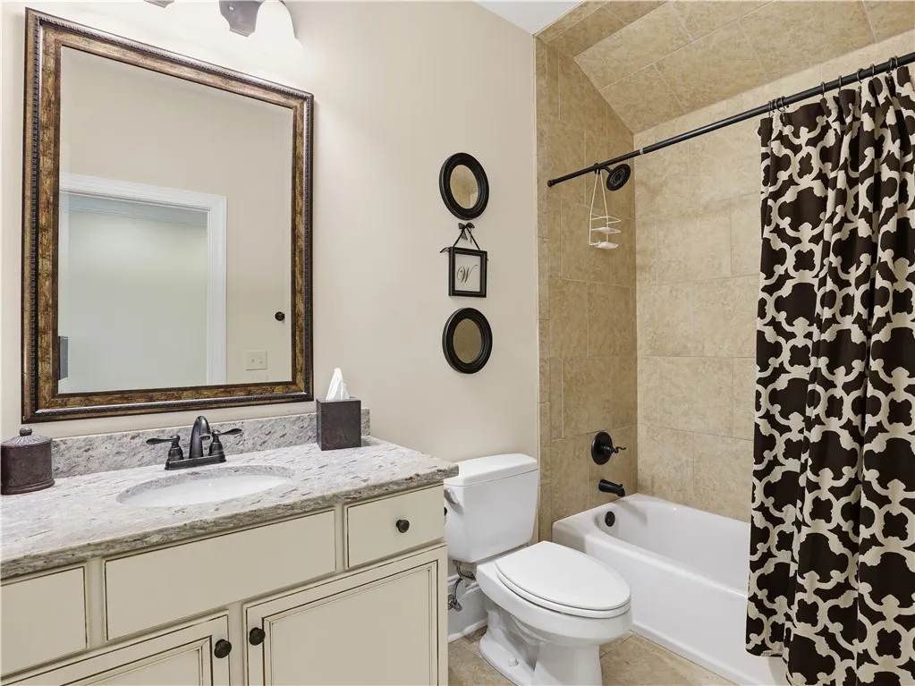 A well-appointed bathroom with a spacious vanity and a neatly tiled shower-tub combination.