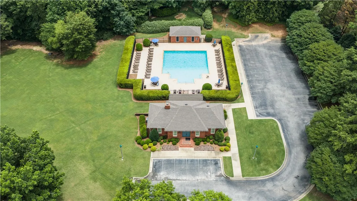 An inviting community pool and clubhouse are nestled within lush landscaping.