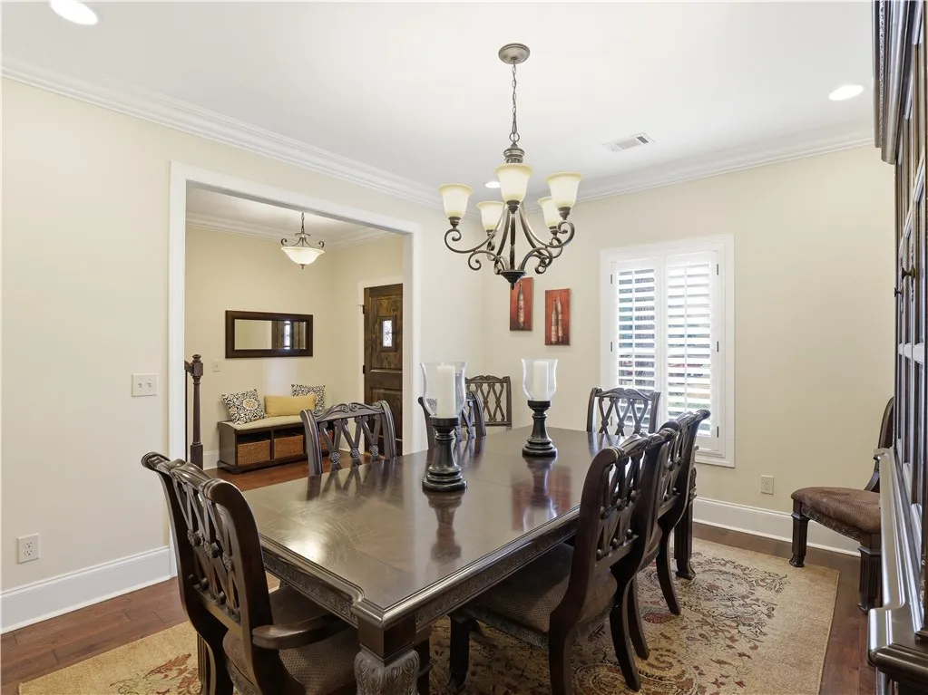 Elegant dining space, perfect for hosting, with exquisite crown molding and hardwood flooring.