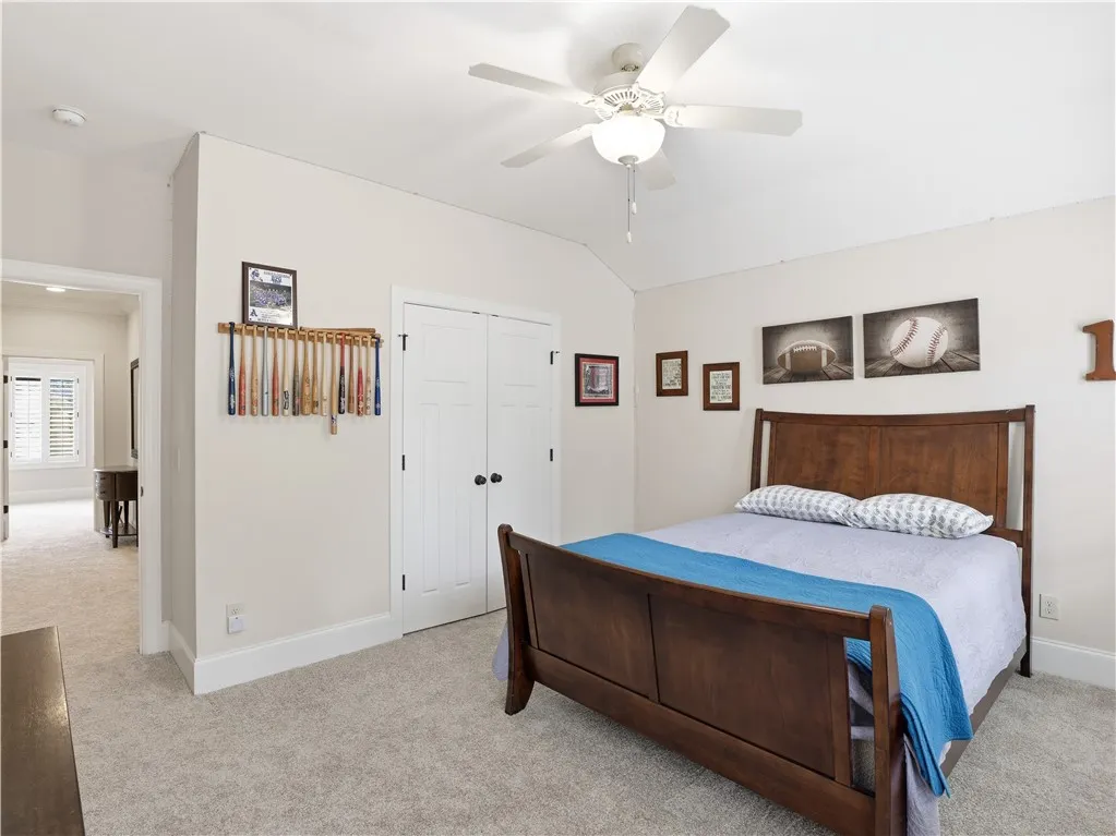 Comfortable bedroom with soft carpet, high ceilings, and double closet doors for ample storage.