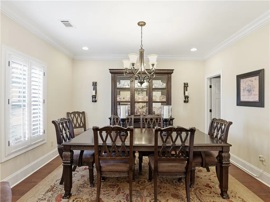 Elegant crown molding and rich hardwood flooring define this inviting dining area.