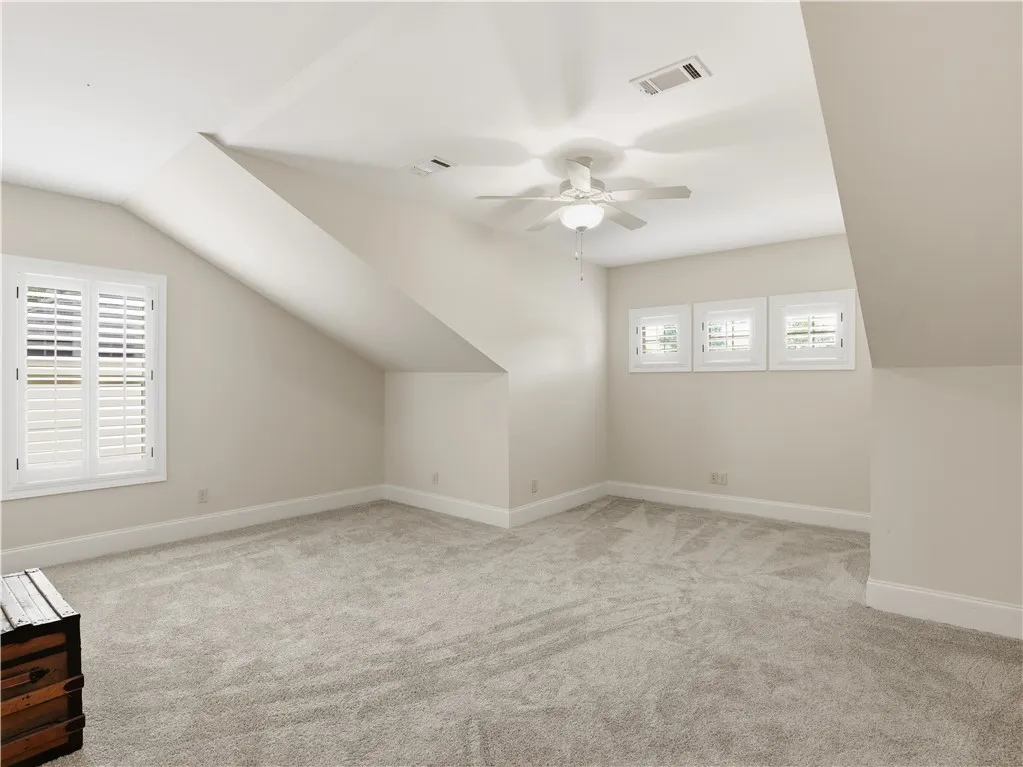 Sloped ceilings and plantation-shuttered windows define this inviting room.