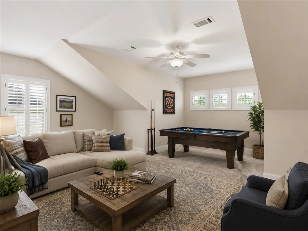 Unwind in this generously sized recreation room, featuring a classic pool table and soft carpeting.