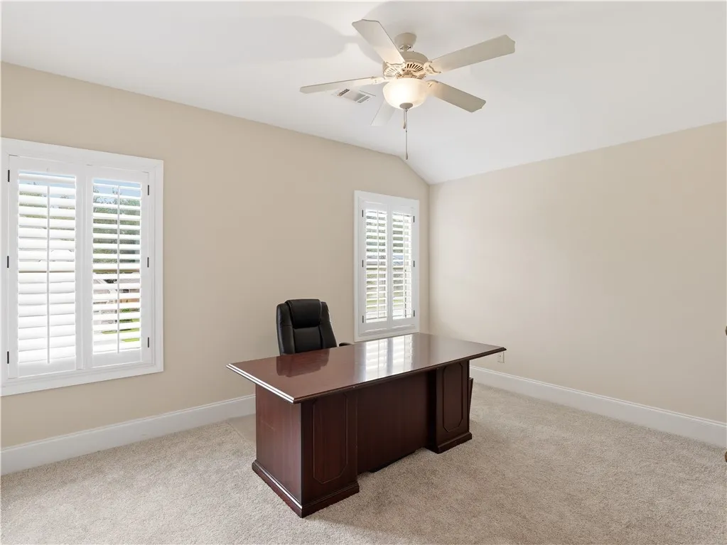 A quiet room for productivity, featuring shuttered windows and a high ceiling.