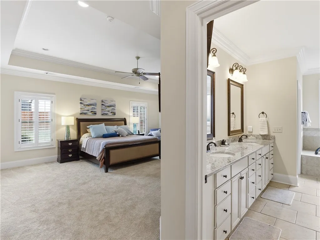 A well-appointed primary suite boasts a tray ceiling and a luxurious ensuite bathroom with dual vanities.