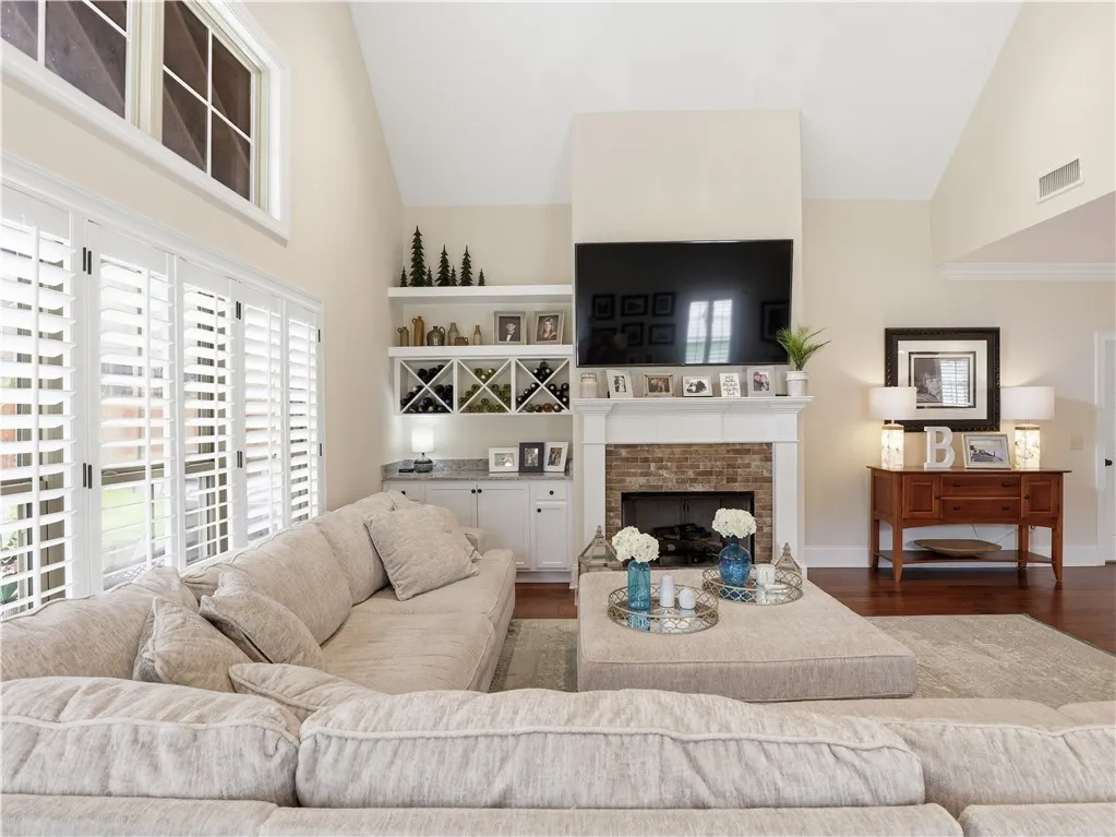 A great room with soaring ceilings and a cozy brick fireplace provides an inviting gathering space.