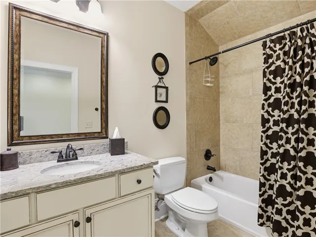 A well-appointed bathroom with a spacious vanity and a neatly tiled shower-tub combination.