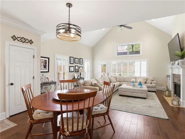 An inviting gathering space features warm wood flooring and a soaring vaulted ceiling with a modern chandelier.
