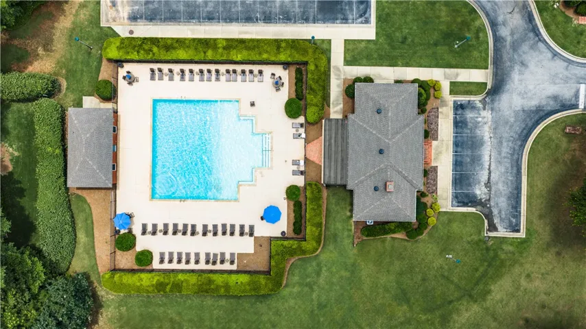 An aerial perspective reveals a vibrant community pool with surrounding lounge areas and manicured landscaping.