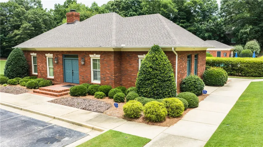 A classic brick exterior, impeccably maintained, welcomes all with lush, manicured landscaping.