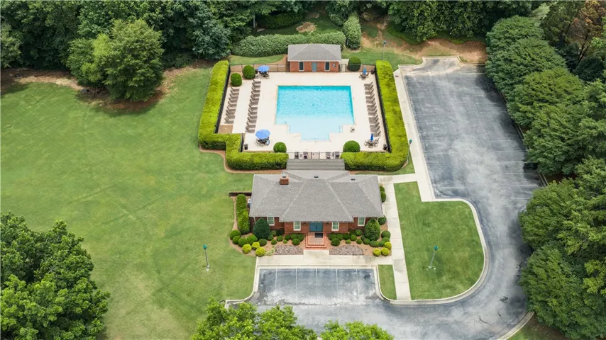 An inviting community pool and clubhouse are nestled within lush landscaping.
