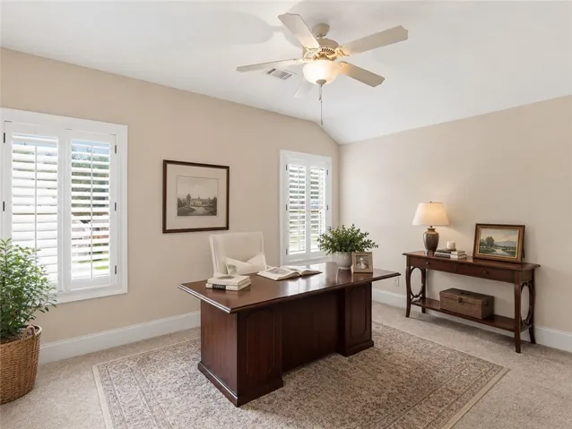Well-lit office with vaulted ceilings and elegant plantation shutters.