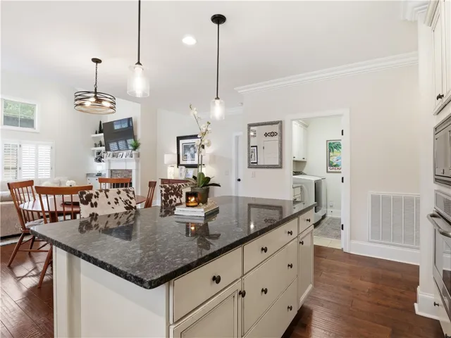 A granite kitchen island provides a central gathering point in this open-concept living space.