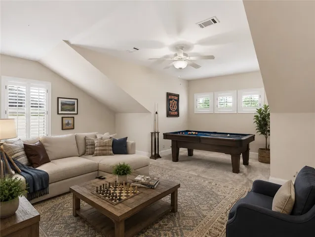 Unwind in this generously sized recreation room, featuring a classic pool table and soft carpeting.