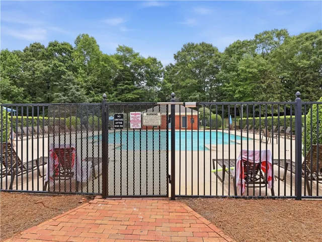 Secure community pool with inviting lounge seating for sun-filled relaxation.