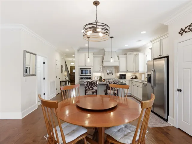 An inviting eat-in kitchen with a kitchen island and a stainless steel refrigerator.