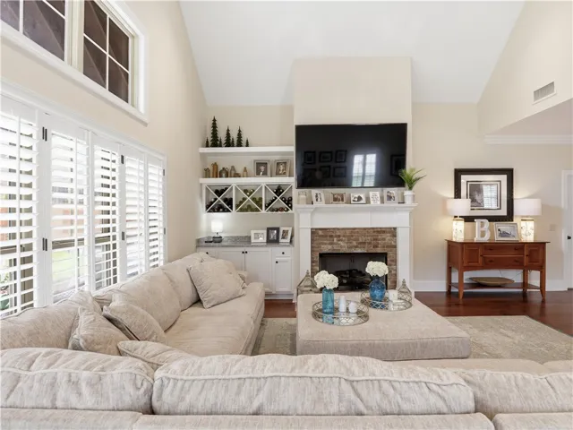 A great room with soaring ceilings and a cozy brick fireplace provides an inviting gathering space.