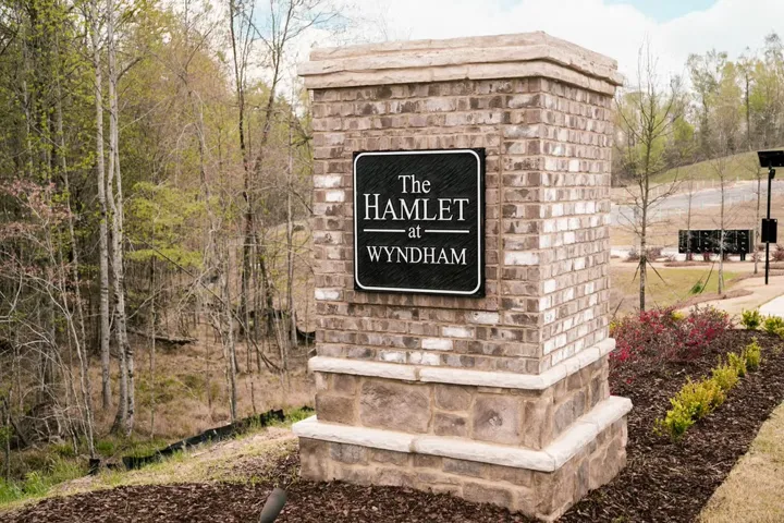 A welcoming brick and stone entrance pillar marks the community's elegant arrival.