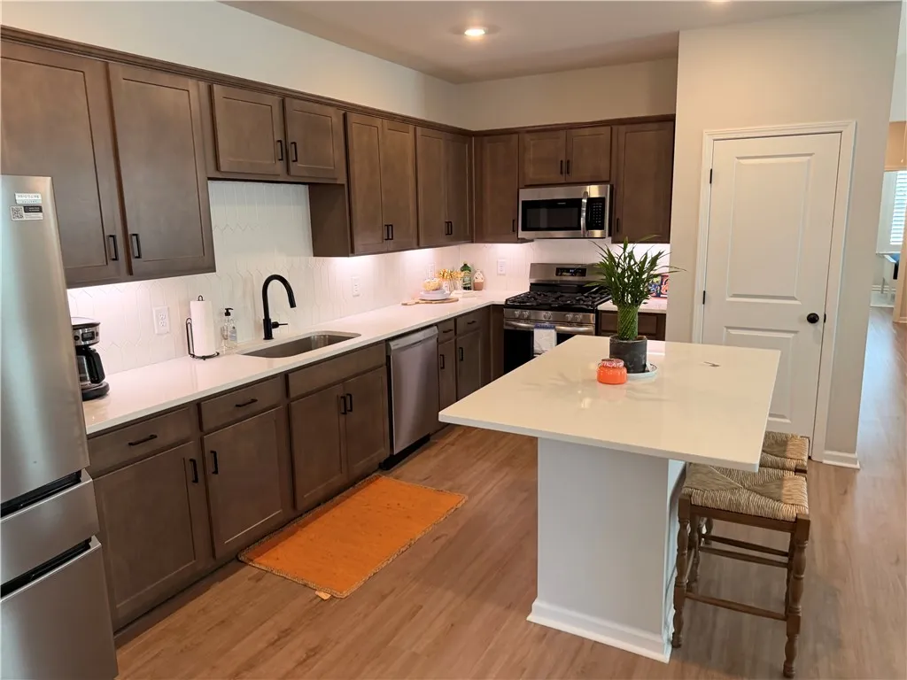 Culinary delights await in this modern kitchen with generous cabinet space with under-cabinet lighting over stone counters with tile splash, and integrated SS appliances that include a microwave over a 5-burner gas stove, and dishwasher. Kitchen island offers an added counterThe SS Gallery series Frigidaire refrigerator is negotiable.