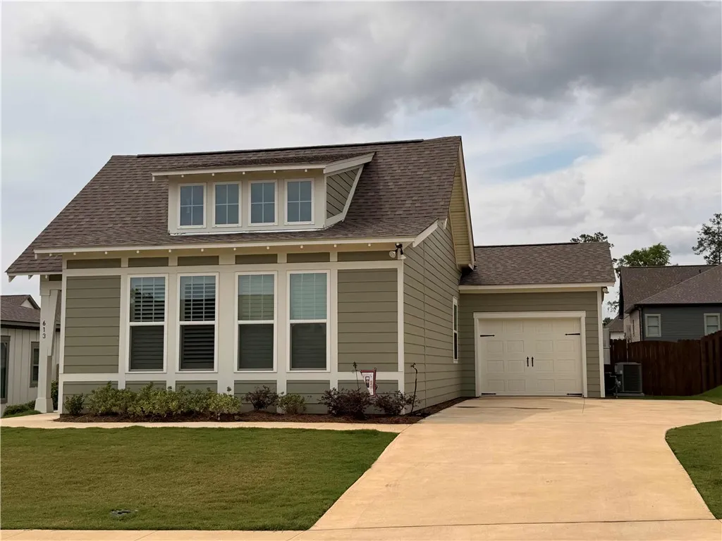 Concrete driveway with added parking pad offers convenience. Single garage offers inviting curb appeal.
