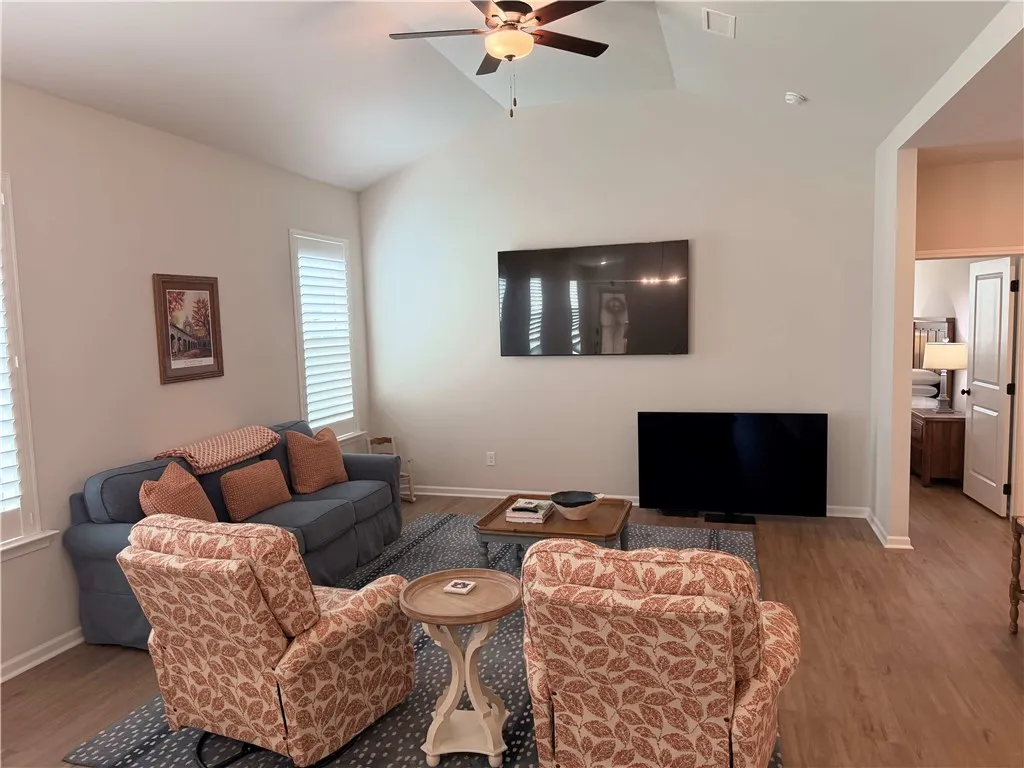 Vaulted ceilings elevate this well-lit living room, offering an inviting atmosphere with newly added plantation shutters. 15x15