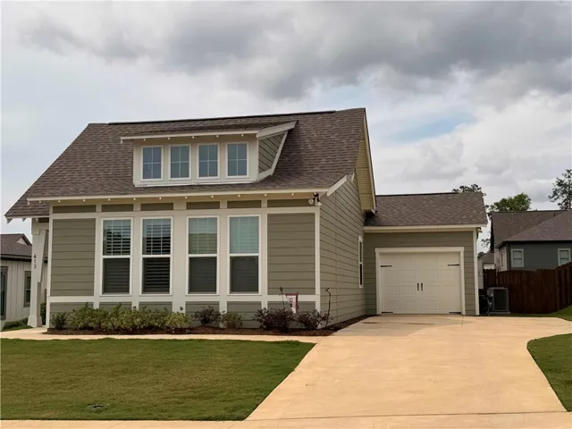 Concrete driveway with added parking pad offers convenience. Single garage offers inviting curb appeal.