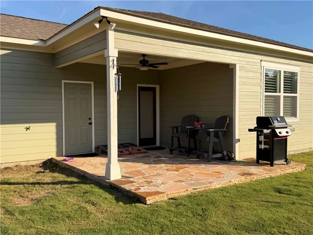 An inviting covered patio featuring flagstone flooring, perfect for outdoor relaxation.
