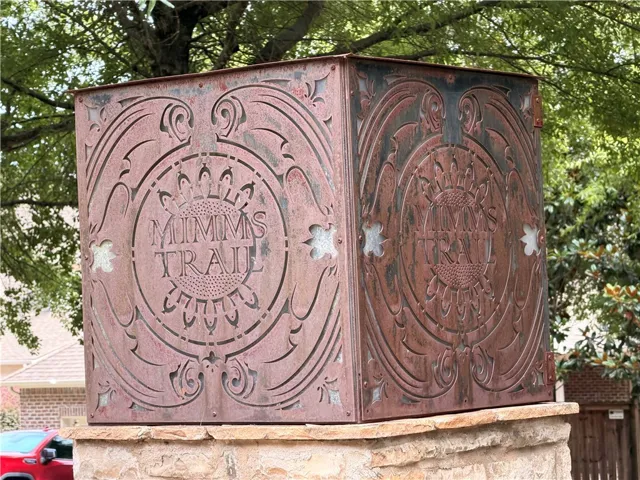 Ornate metalwork sculpture announces the entrance to Mimms Trail, adding character to the streetscape.